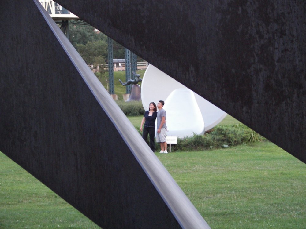 Couple posing in front of Spoonbridge and Cherry through Nautilus