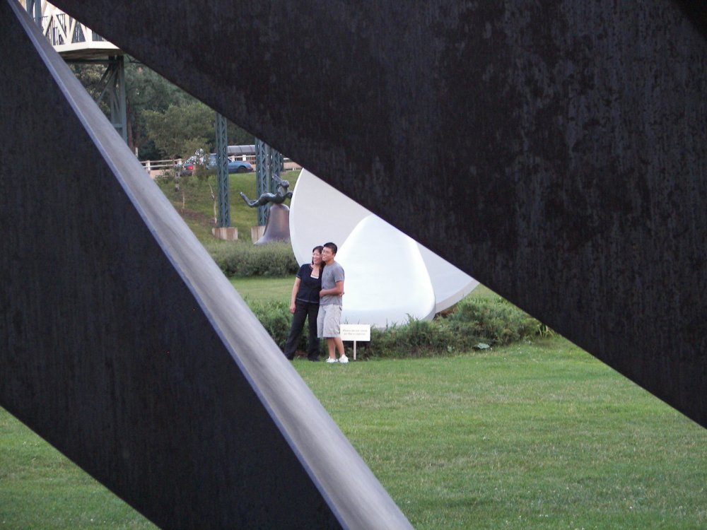 Couple posing in front of Spoonbridge and Cherry through Nautilus